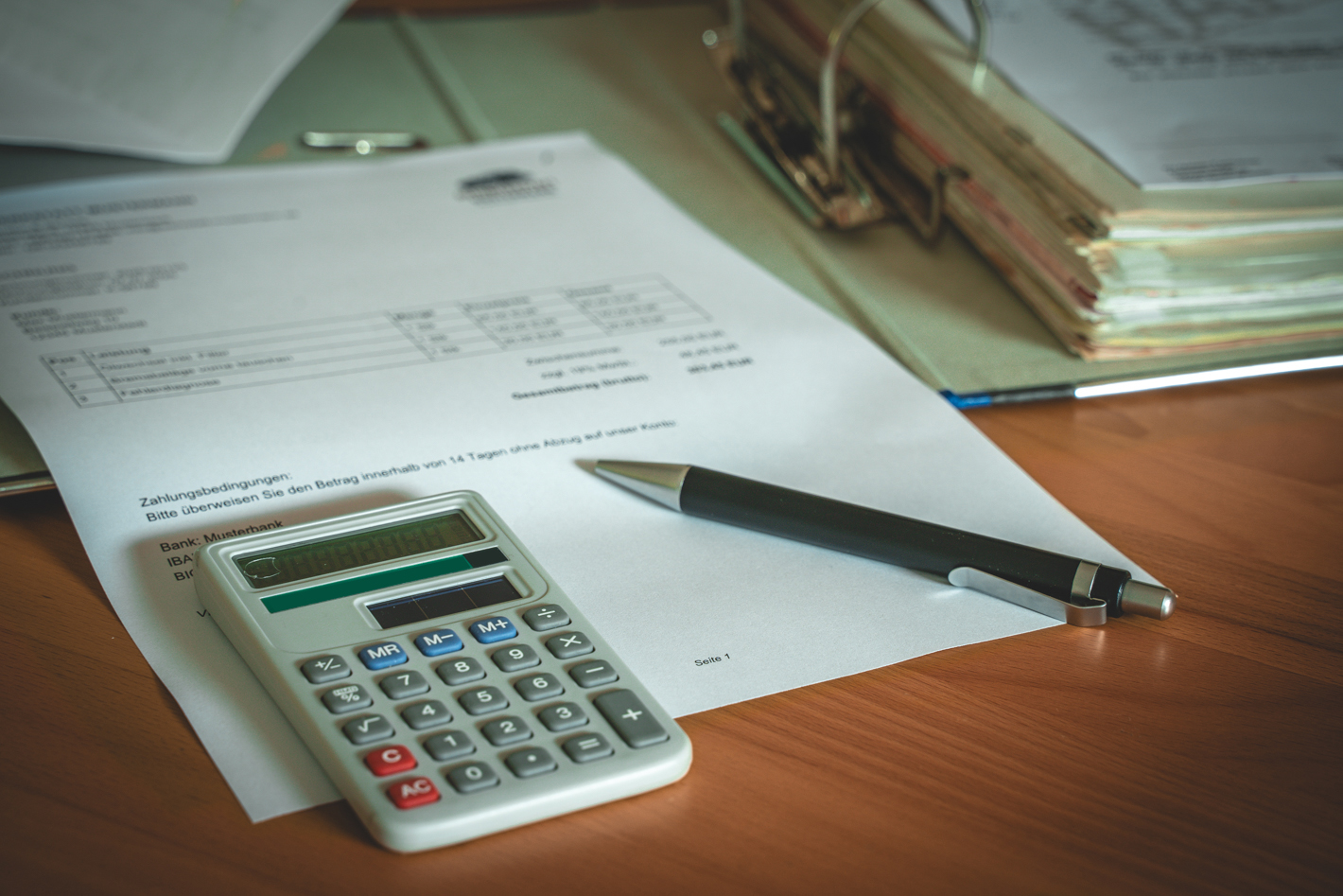 ornder mit rechnungen, taschenrechner und kuli